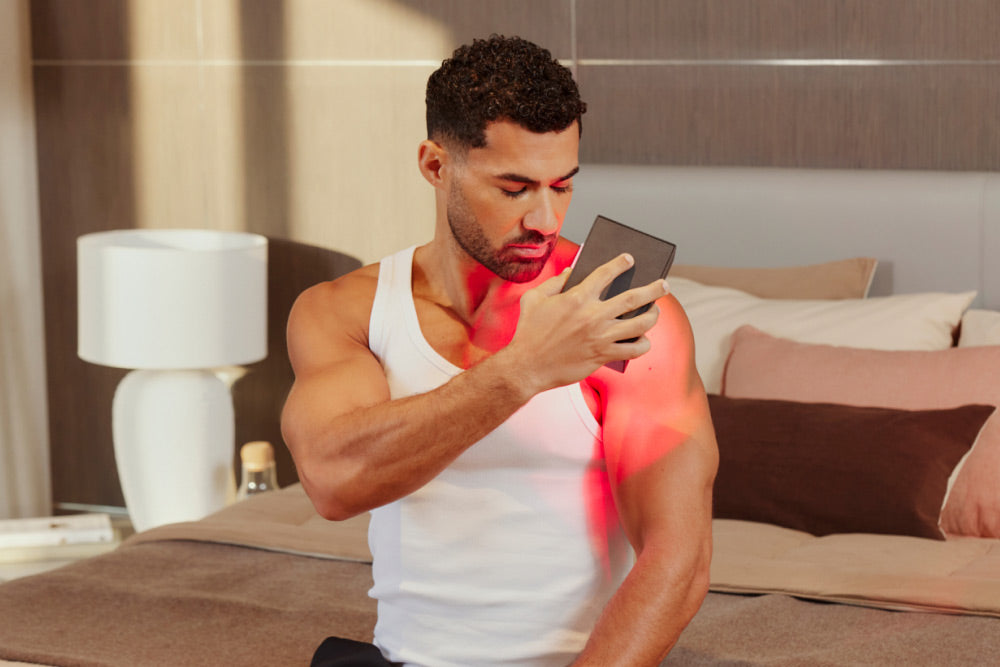 Man Using Mini Red Light Device on Shoulder
